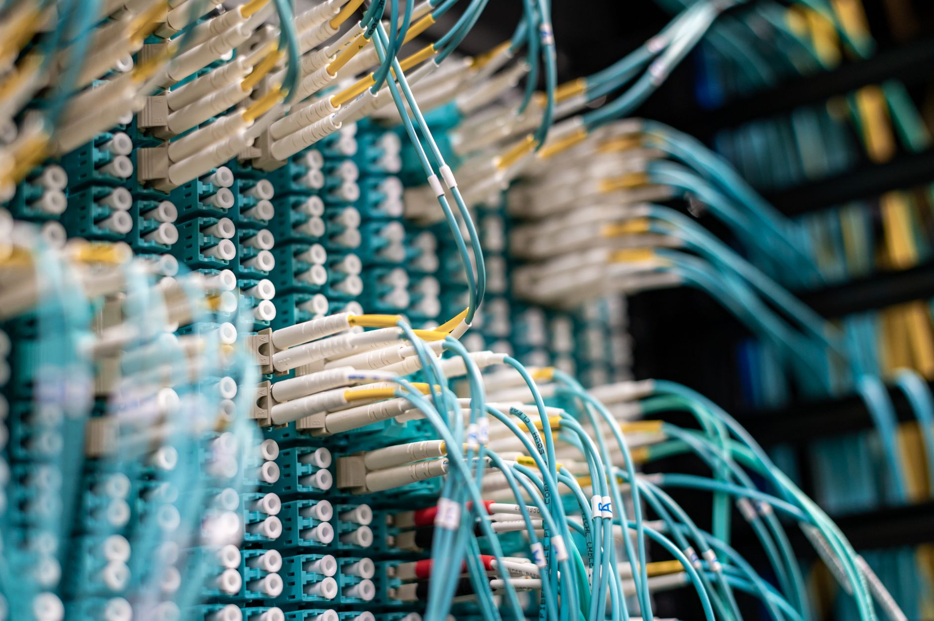 at&t fiber optic cable repair - From below of long thin blue cables connected to row of small white connectors on system block in data center