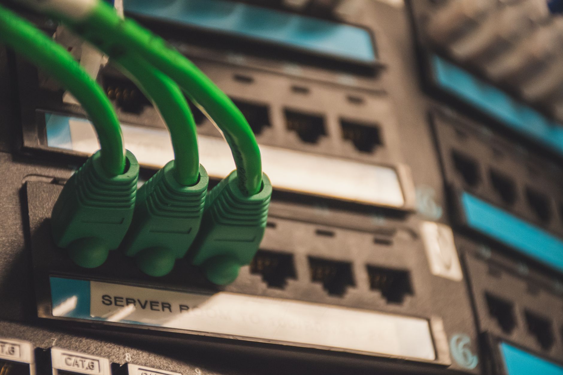 how to reset network settings in windows 10 - Close-up of green network cables plugged into server ports, showcasing technology setup.