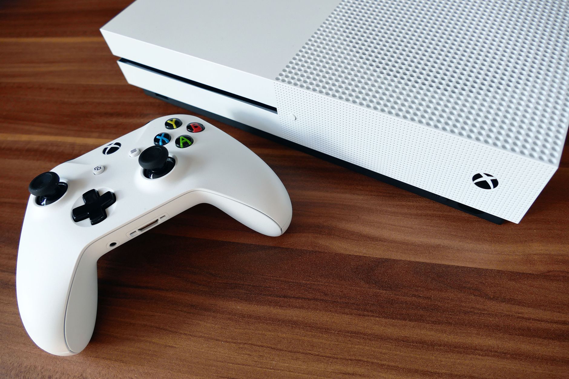 microsoft surface won't connect to wifi - Close-up of a white Xbox console and controller on a wooden surface, ideal for gaming enthusiasts.