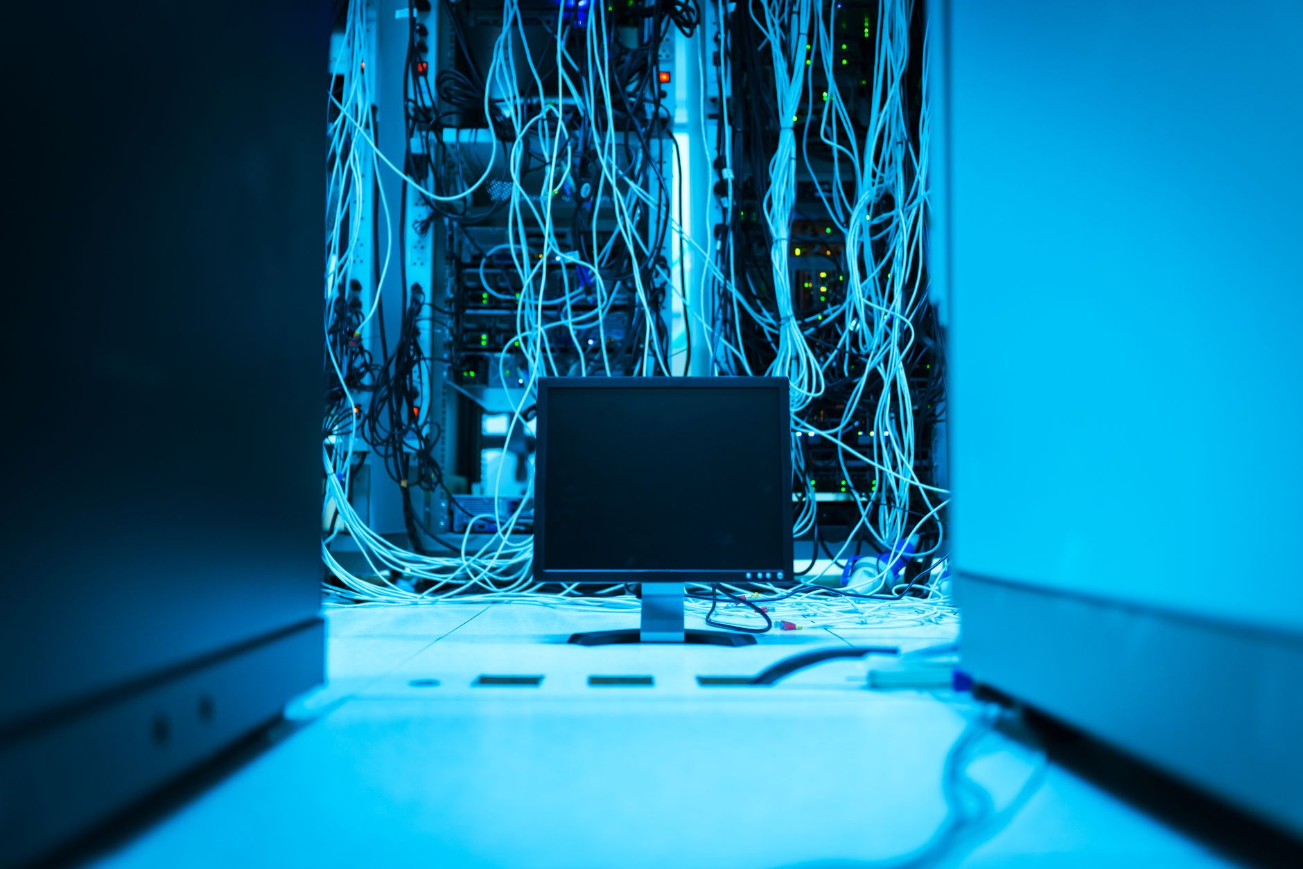 no internet on computer - A complex network of cables in a data center with a monitor in the foreground.