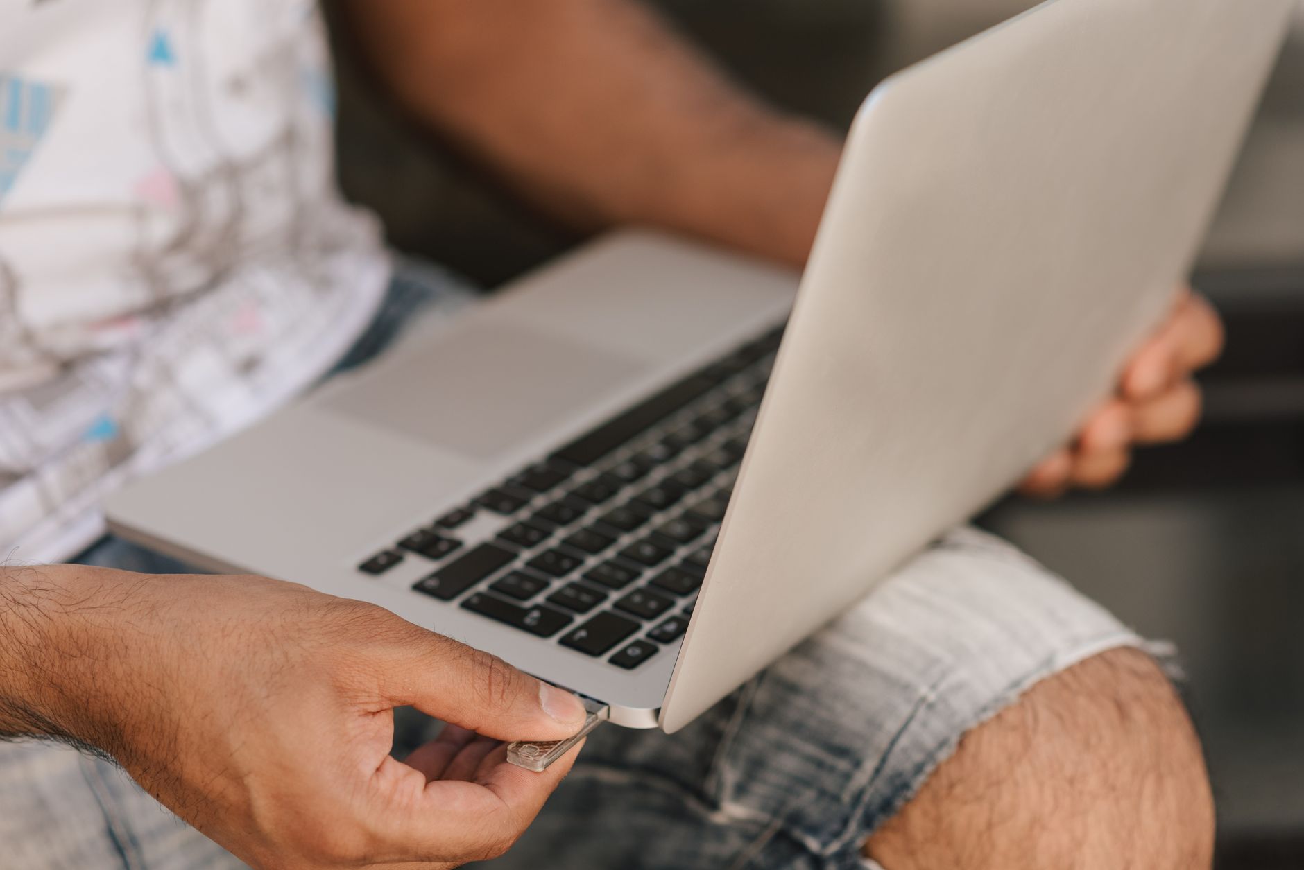 pc is connected but no internet - Crop unrecognizable male in casual shorts working on modern netbook placed on laps and inserting memory card in slot