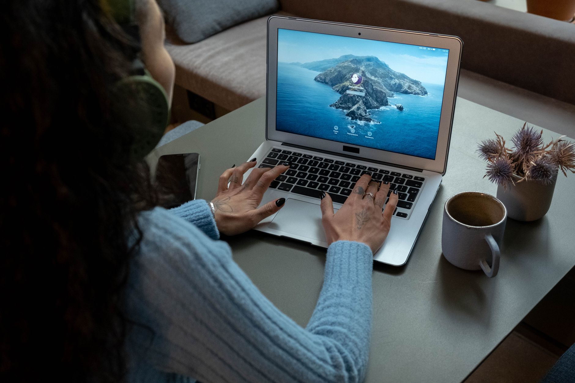 pc is connected but no internet - A woman wearing headphones works on a laptop at a cozy home office with a cup of coffee nearby.