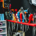 Essential tools for electronics repair including a multimeter, screwdrivers, and pliers