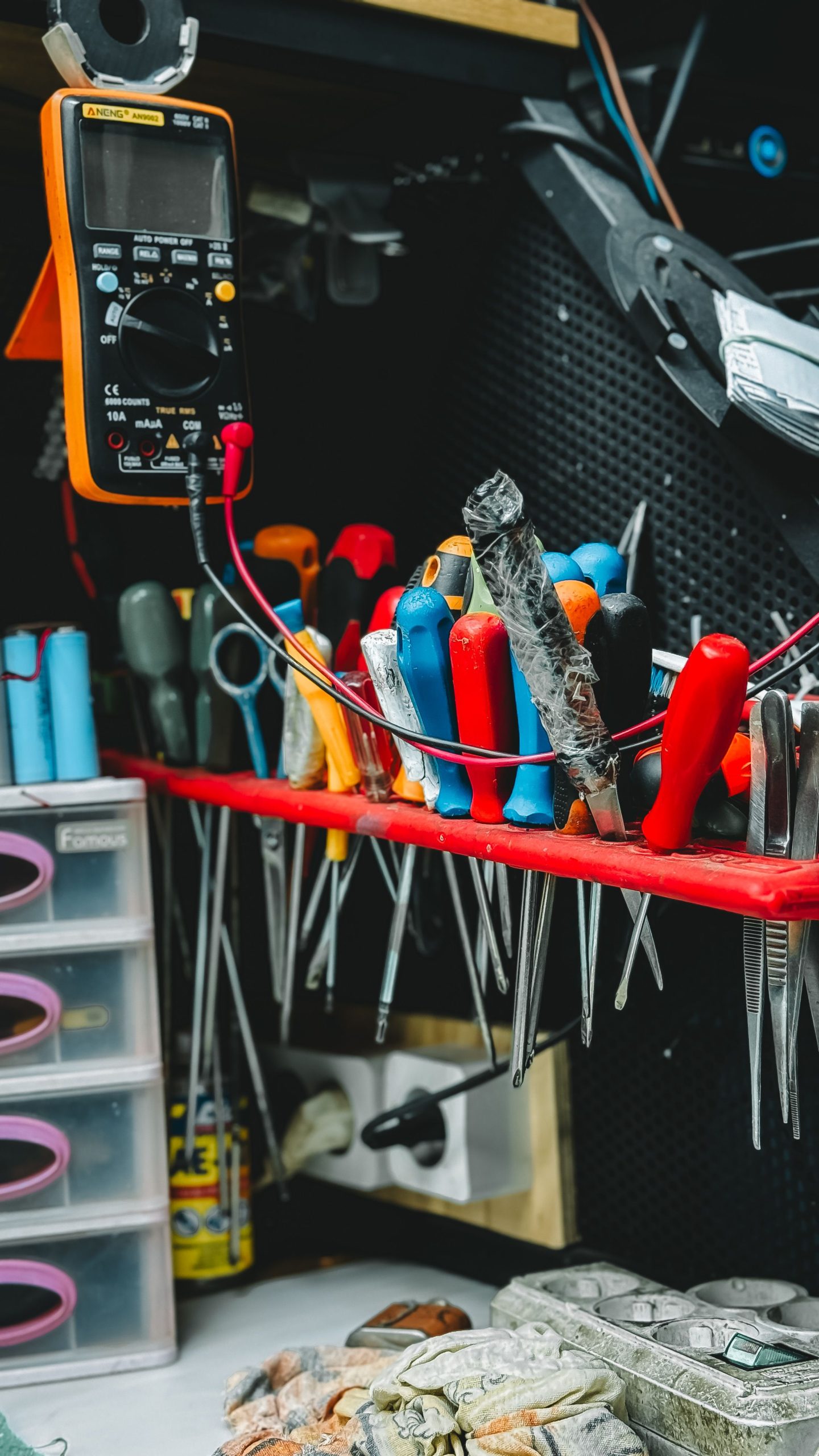 Essential tools for electronics repair including a multimeter, screwdrivers, and pliers