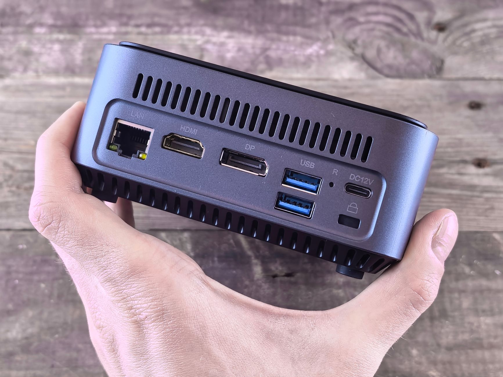 reset lan adapter windows 10 - Close-up of a compact computer showing various ports held in a person's hand.