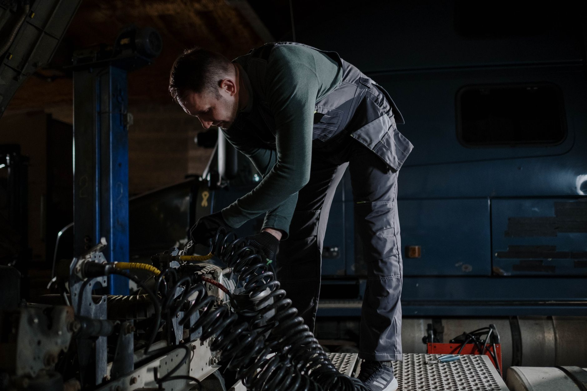 route 19 heavy truck repair - Mechanic fixing truck components indoors at an automotive repair shop.