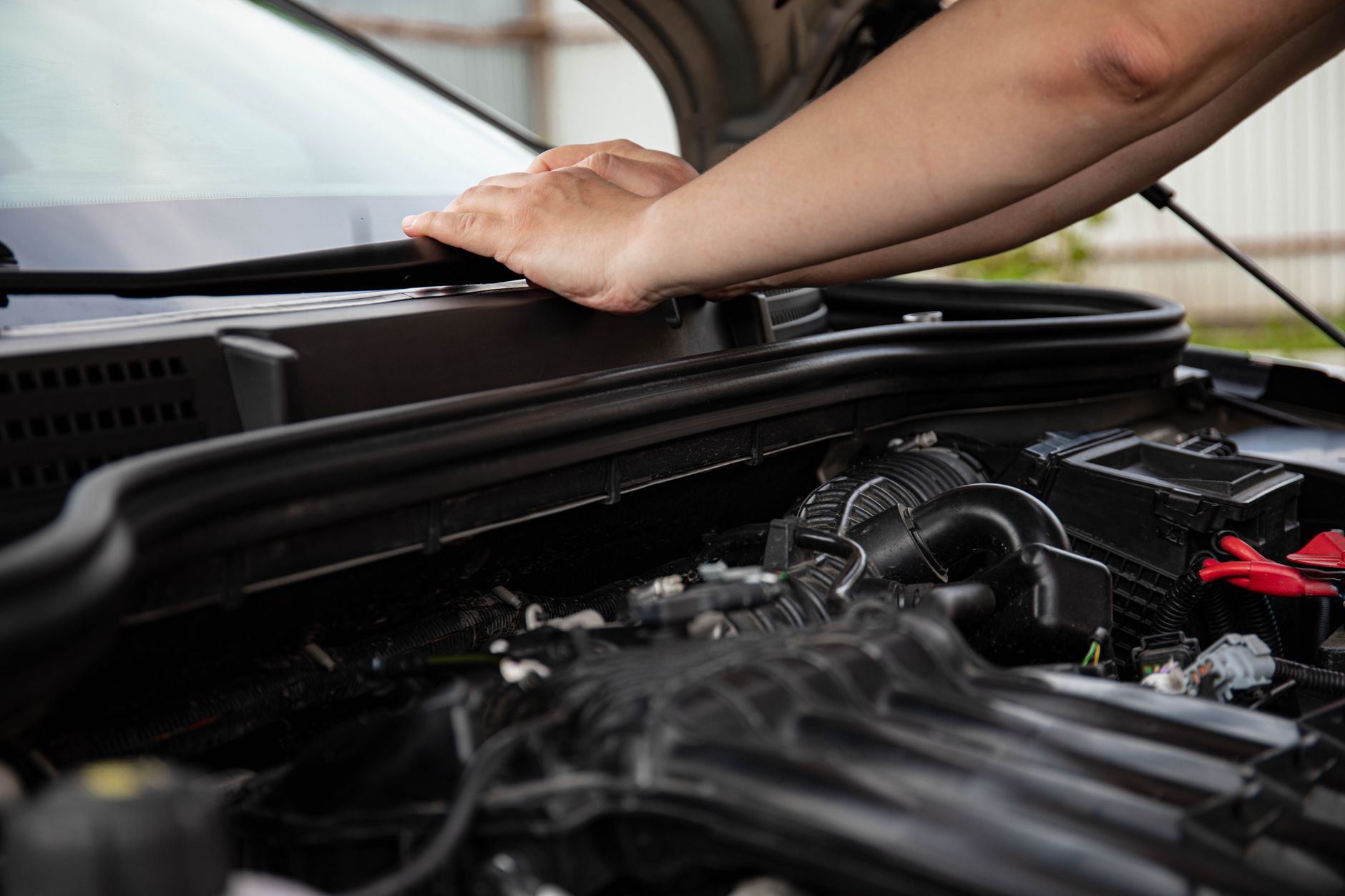 route 401 auto repair - Close-up of hands working on car engine. Detailed view of automotive repair.