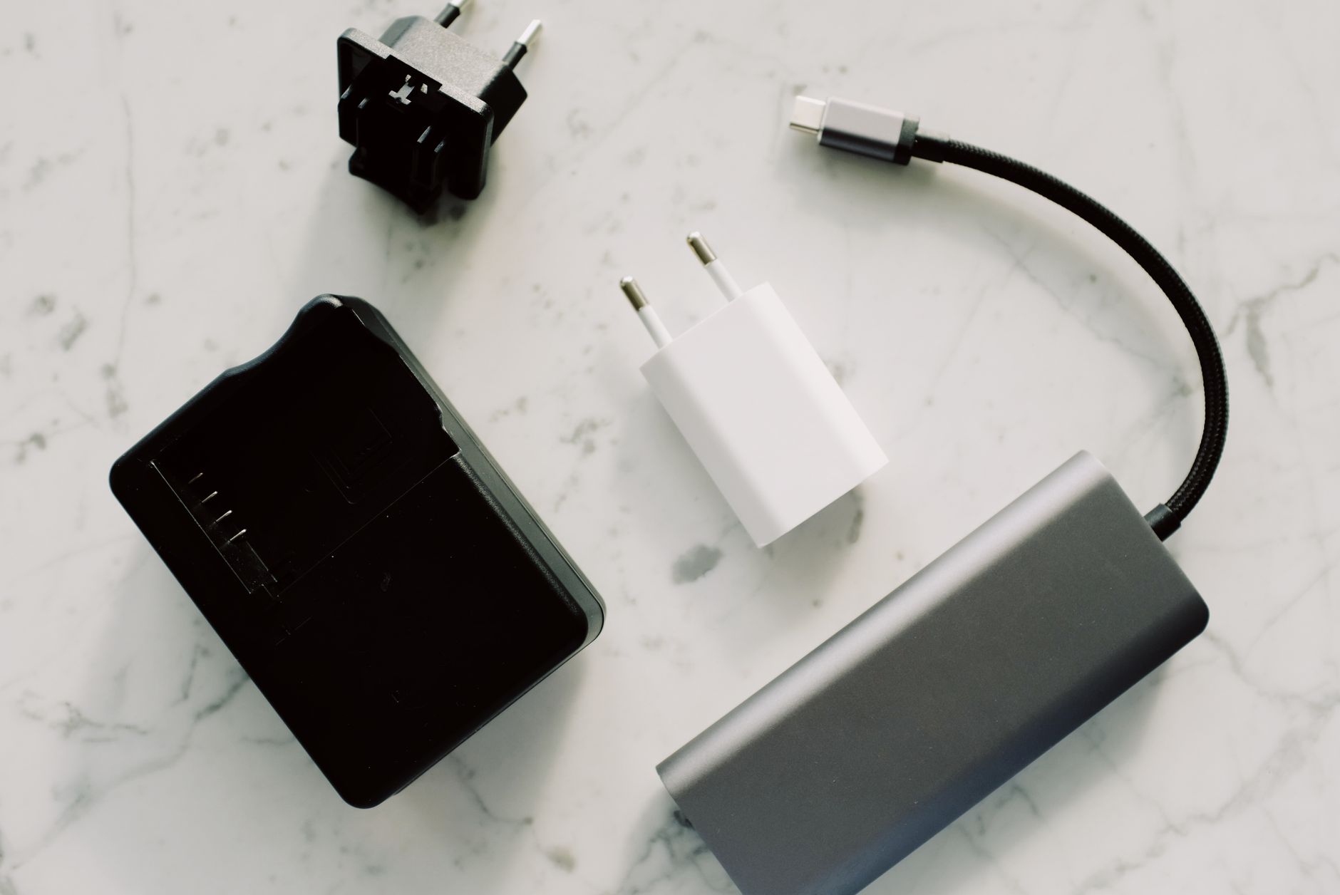 usb wifi adapter not working - A collection of electronic adapters and cables on a marble surface, showcasing tech essentials.