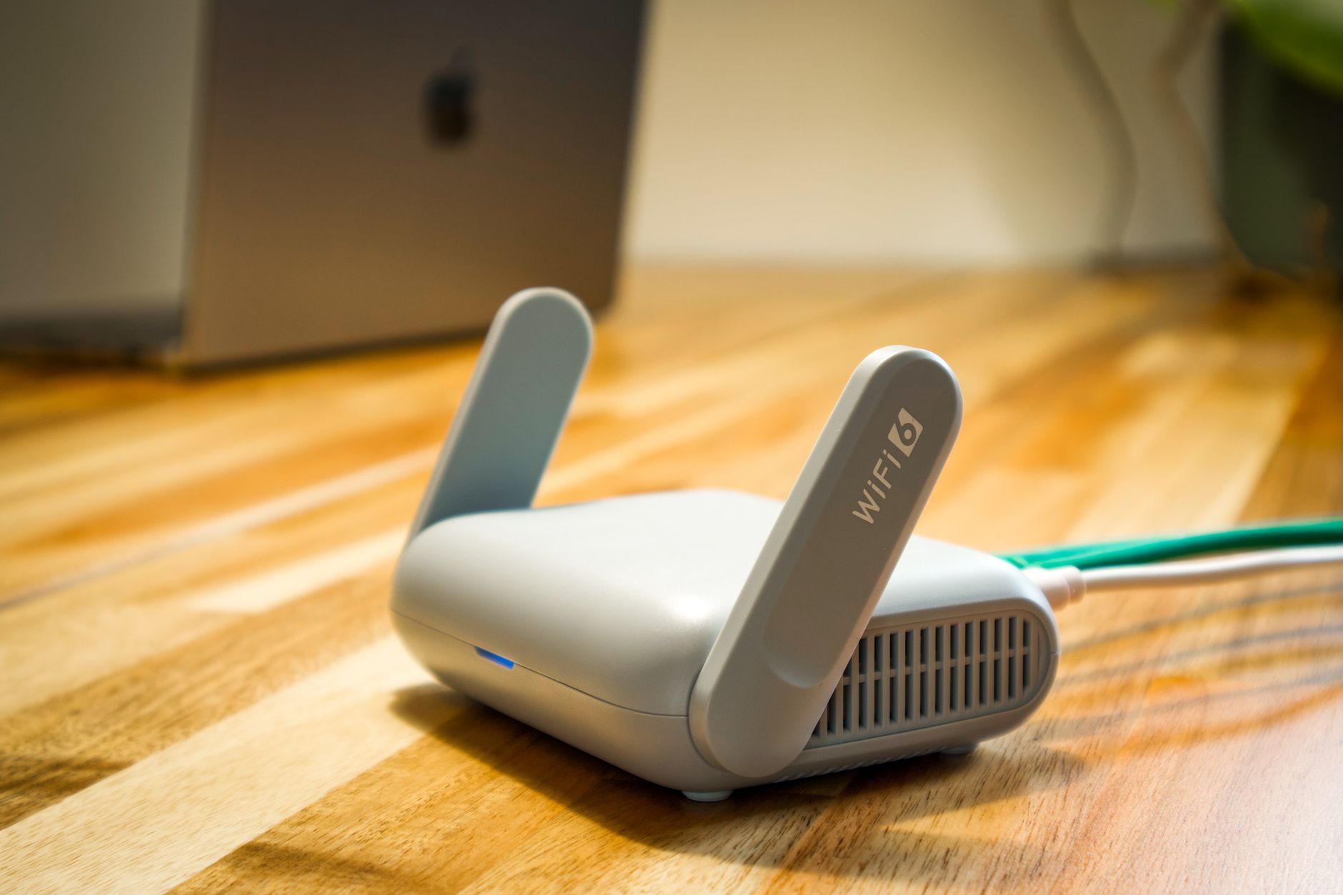 why won't my laptop connect to the wifi - A sleek WiFi 6 router with antennas and cable on a wooden desk, perfect for modern home networks.