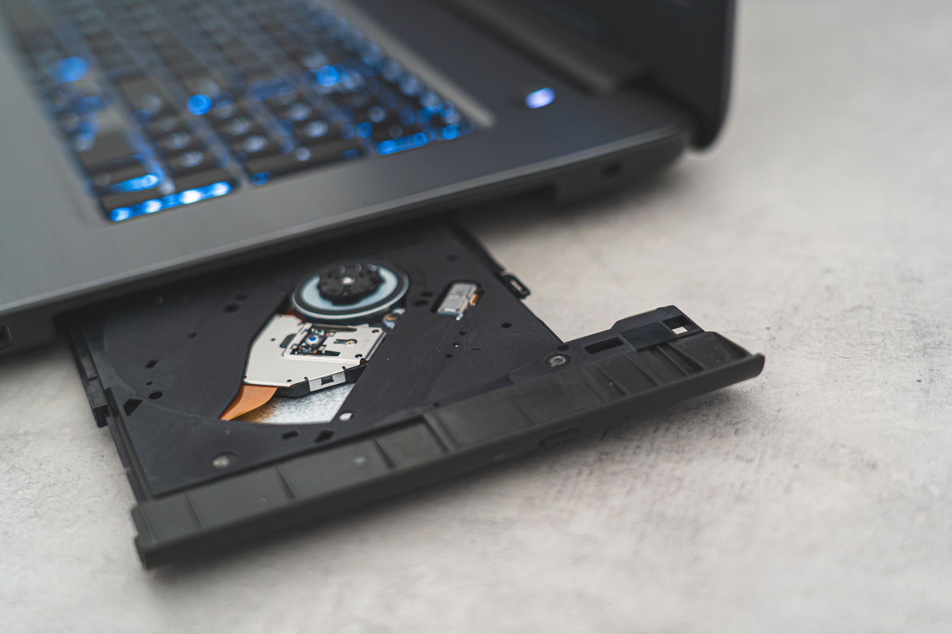 wifi usb adapter not working - Modern laptop showing open CD drive, highlighting optical disk technology.