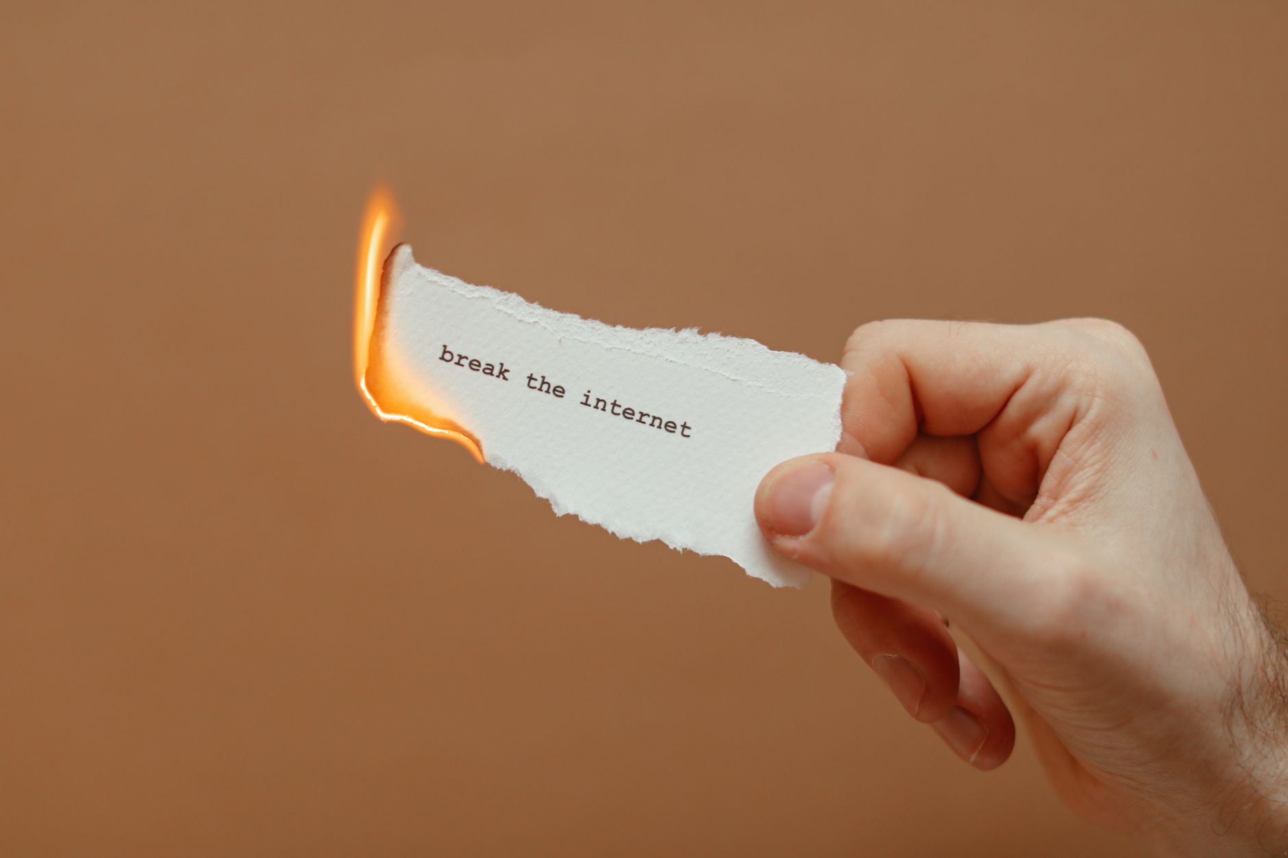 wifire won't connect - Close-up of a hand holding a burning paper with 'break the internet' text.
