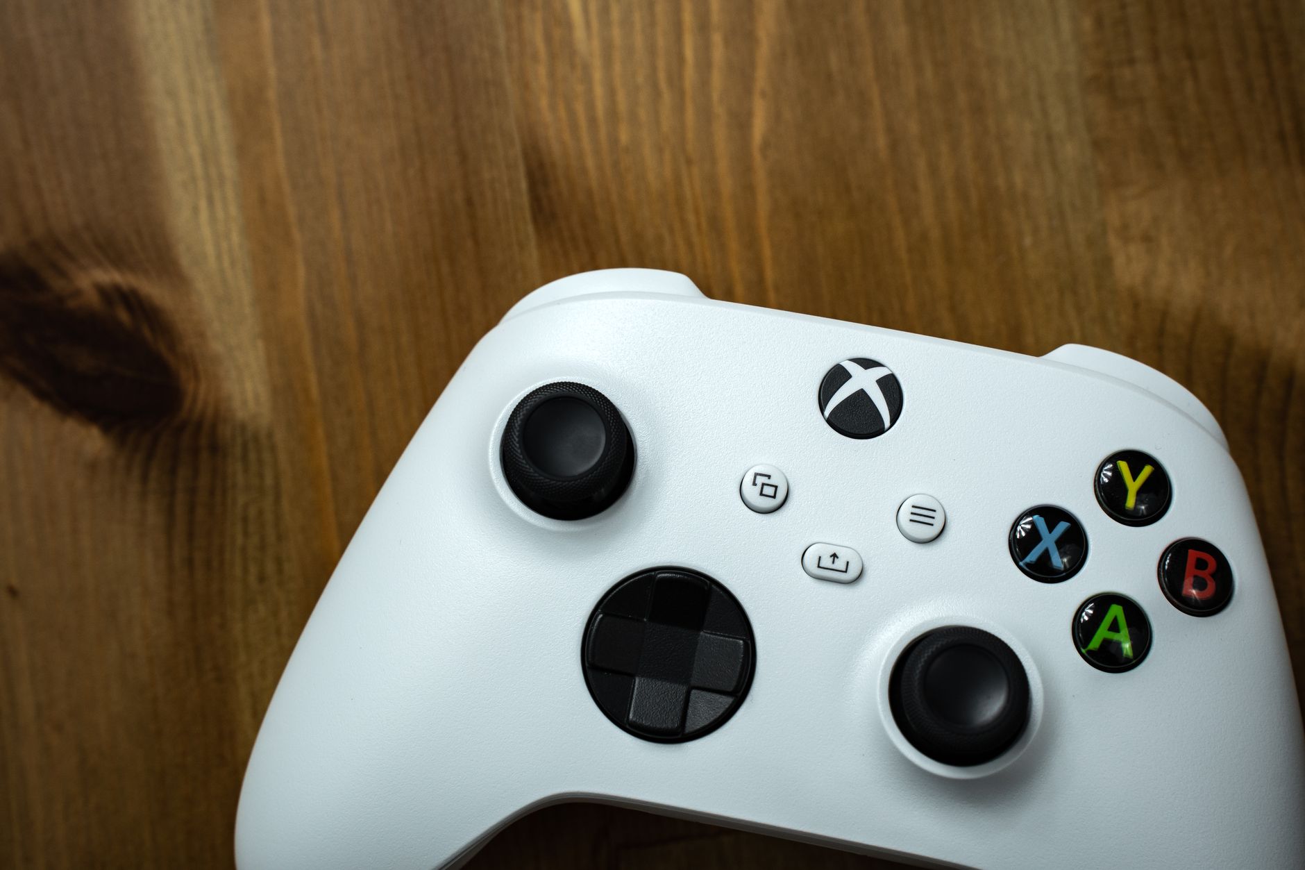 xbox won t connect to wifi but everything else does - Close-up of a white game controller on a rustic wooden surface.
